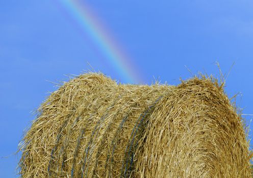 a straw bale under rainbow