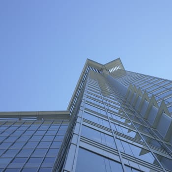 Tall glass building against blue sky