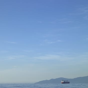 Large vessel on the ocean with mountains in the background