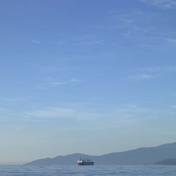 Large vessel on the ocean with mountains in the background