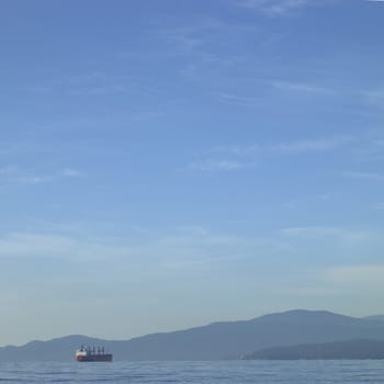 Large vessel on the ocean with mountains in the background