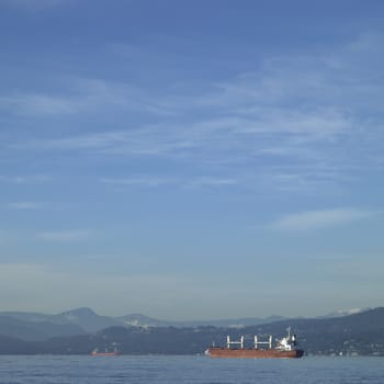 Large vessel on the ocean with mountains in the background