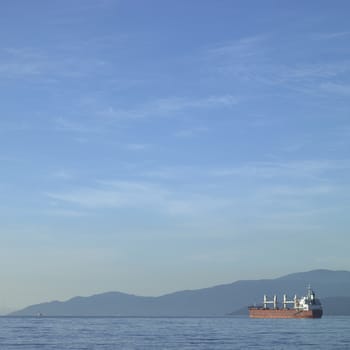 Large vessel on the ocean with mountains in the background