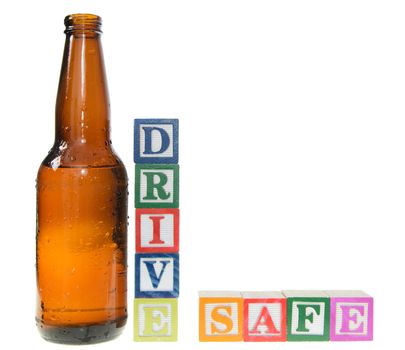 Letter blocks spelling drive safe with a beer bottle. Isolated on a white background