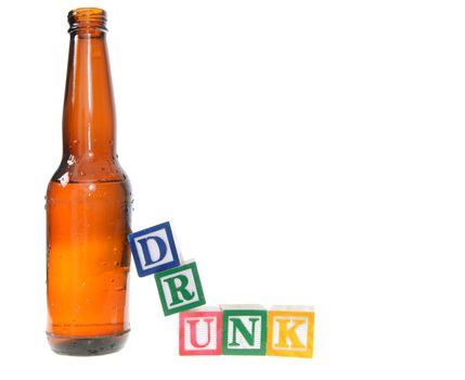 Letter blocks spelling drunk with a beer bottle. Isolated on a white background