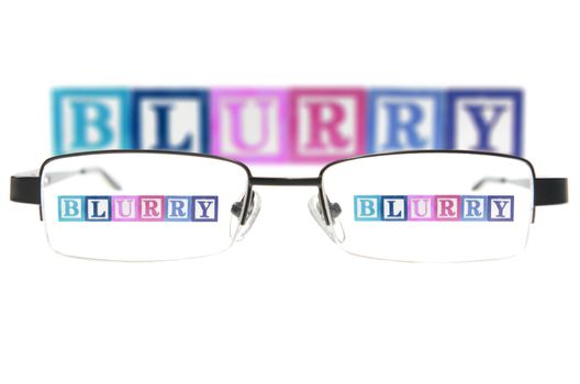 Letter blocks spelling blurry through glasses. Isolated on white