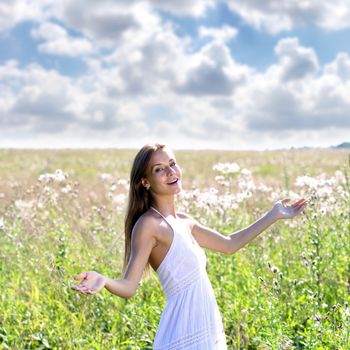 Happy young woman walks in summer field