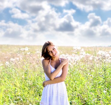 Young woman in dress walking on a meadow