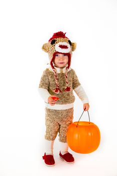 A two year old dressed up in a sock monkey halloween costume and ready to go out and trick-or-treat in the neighborhood for the holiday.