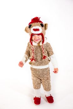 A two year old dressed up in a sock monkey halloween costume and ready to go out and trick-or-treat in the neighborhood for the holiday.