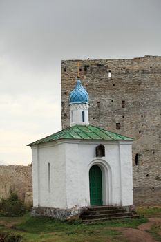 Chapel on the background of the ruined city wall. Pskov. Russia
