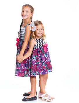 Two beautiful little girls happy smiling on studio. Isolated white background
