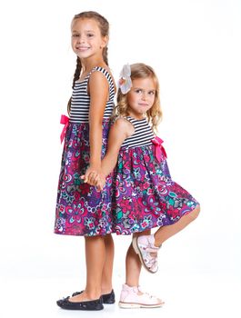 Two beautiful little girls happy smiling on studio. Isolated white background