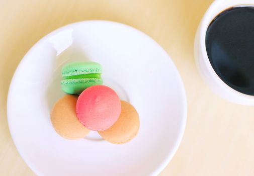 Colorful macaroons and cup of coffee with retro filter effect