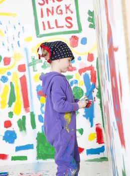 Young artist painting a wall