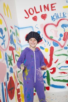 Smiling young artist painting in a white room