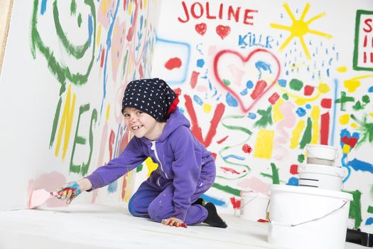 Young Artist paitning a white room with a smile on her face