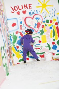 Young Artist Girl painting a wall