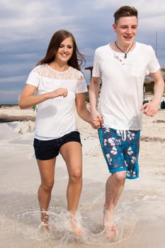 happy young couple on the beach in summer holiday love togetherness