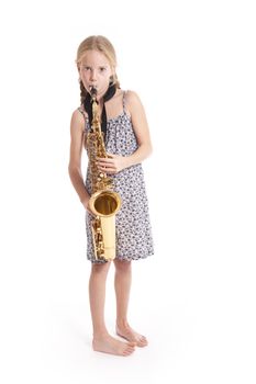 young girl in dress and her saxophone standing in studio against white background