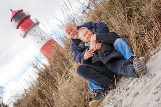 happy mature couple relaxing baltic sea dunes in autumn