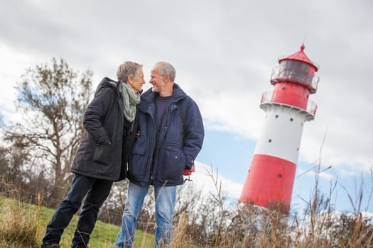 happy mature couple relaxing baltic sea dunes in autumn