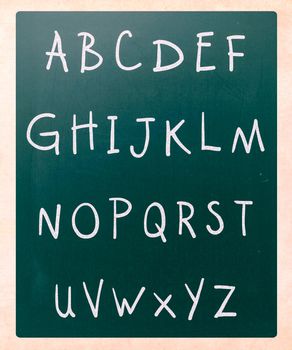 Complete english alphabet handwritten with white chalk on a blackboard