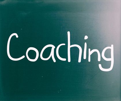 "Coaching" handwritten with white chalk on a blackboard