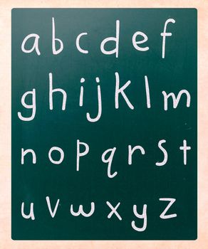 Complete english alphabet handwritten with white chalk on a blackboard