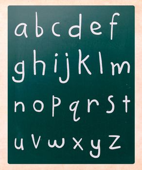 Complete english alphabet handwritten with white chalk on a blackboard