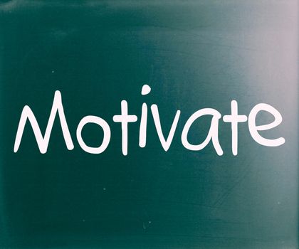 "Motivate" handwritten with white chalk on a blackboard