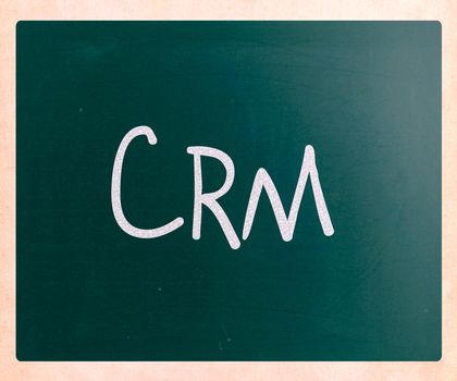 The word "CRM" handwritten with white chalk on a blackboard