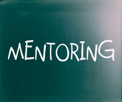 The word "Mentoring" handwritten with white chalk on a blackboard