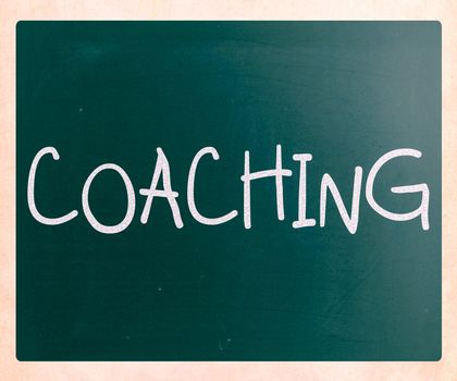 "Coaching" handwritten with white chalk on a blackboard