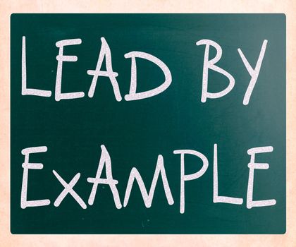 "Lead by example" handwritten with white chalk on a blackboard