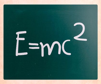 E=mc2 handwritten with white chalk on a blackboard