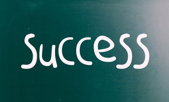 The word "Success" handwritten with white chalk on a blackboard