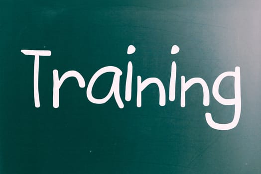 The word "Training" handwritten with white chalk on a blackboard