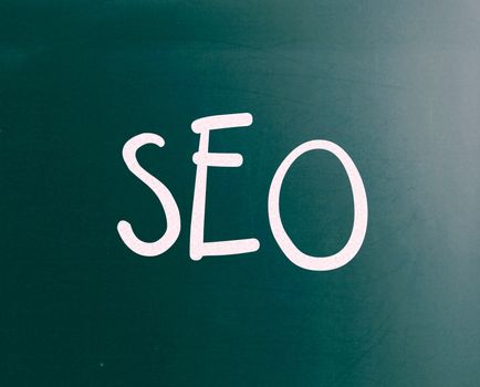The word "SEO" handwritten with white chalk on a blackboard