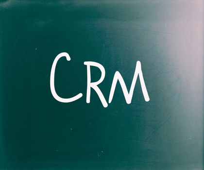 The word "CRM" handwritten with white chalk on a blackboard