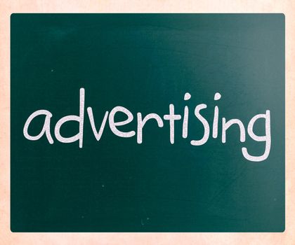 The word "advertising" handwritten with white chalk on a blackboard