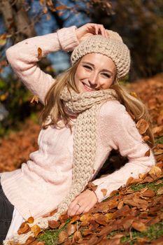 young smiling woman with hat and scarf outdoor in autumn nature background