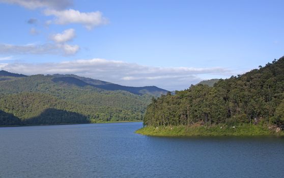 Natural forest landscape mountains sky water clouds.