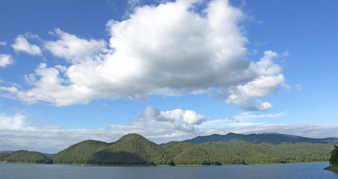 Natural forest landscape mountains sky water clouds.