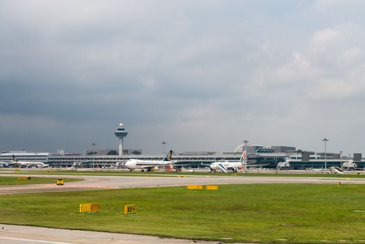 SINGAPORE - SEP 11: Singapore airlines and Jetstar airways planes stand in Changi airport on SEP 11, 2012  in Singapore. Changi International Airport is the main airport in Singapore.