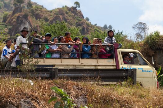 DIENG PLATEAU, INDONESIA - SEP 12: Public truck transport on Sep 12, 2012  in Dieng Plateau, Central Java island, Indonesia. Common road scene - truck with many happy people.