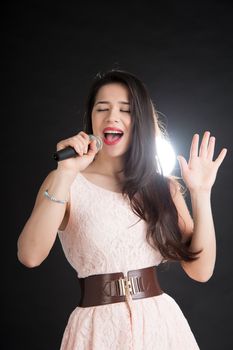 beautiful singer on a black background with a microphone