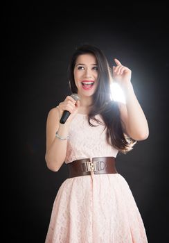 beautiful singer on a black background with a microphone