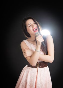 beautiful singer on a black background with a microphone