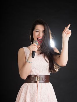 beautiful singer on a black background with a microphone